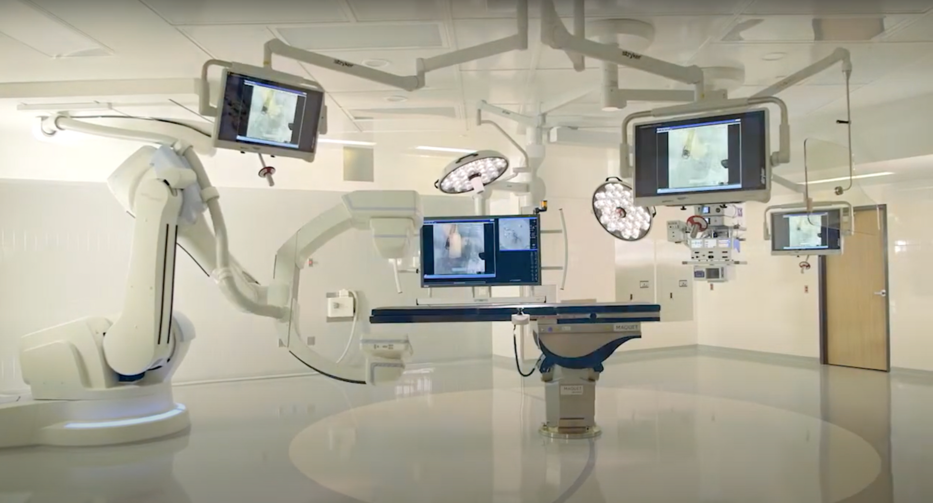 A surgical room with a robotic arm and monitors.