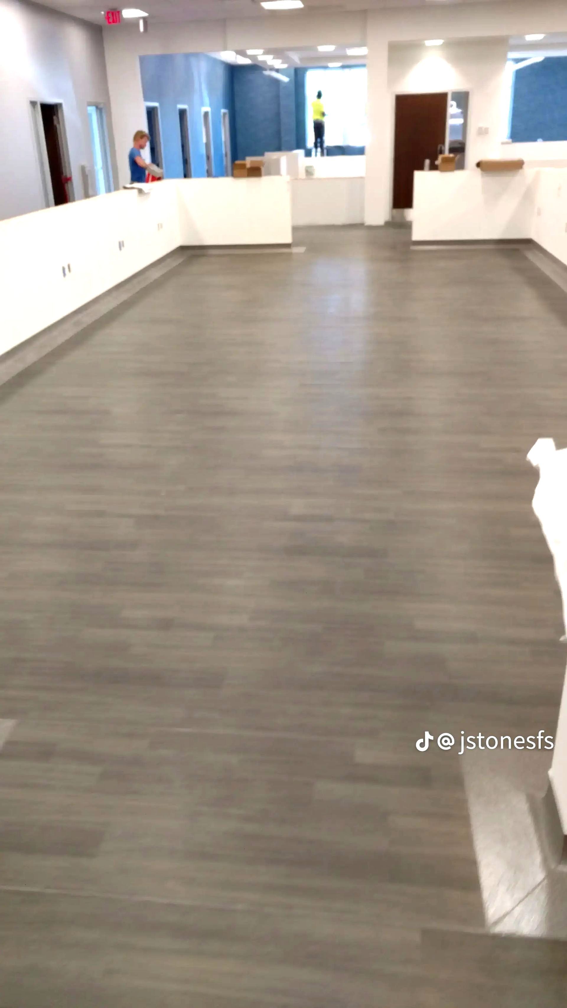 A large room with a wooden floor and a white wall.