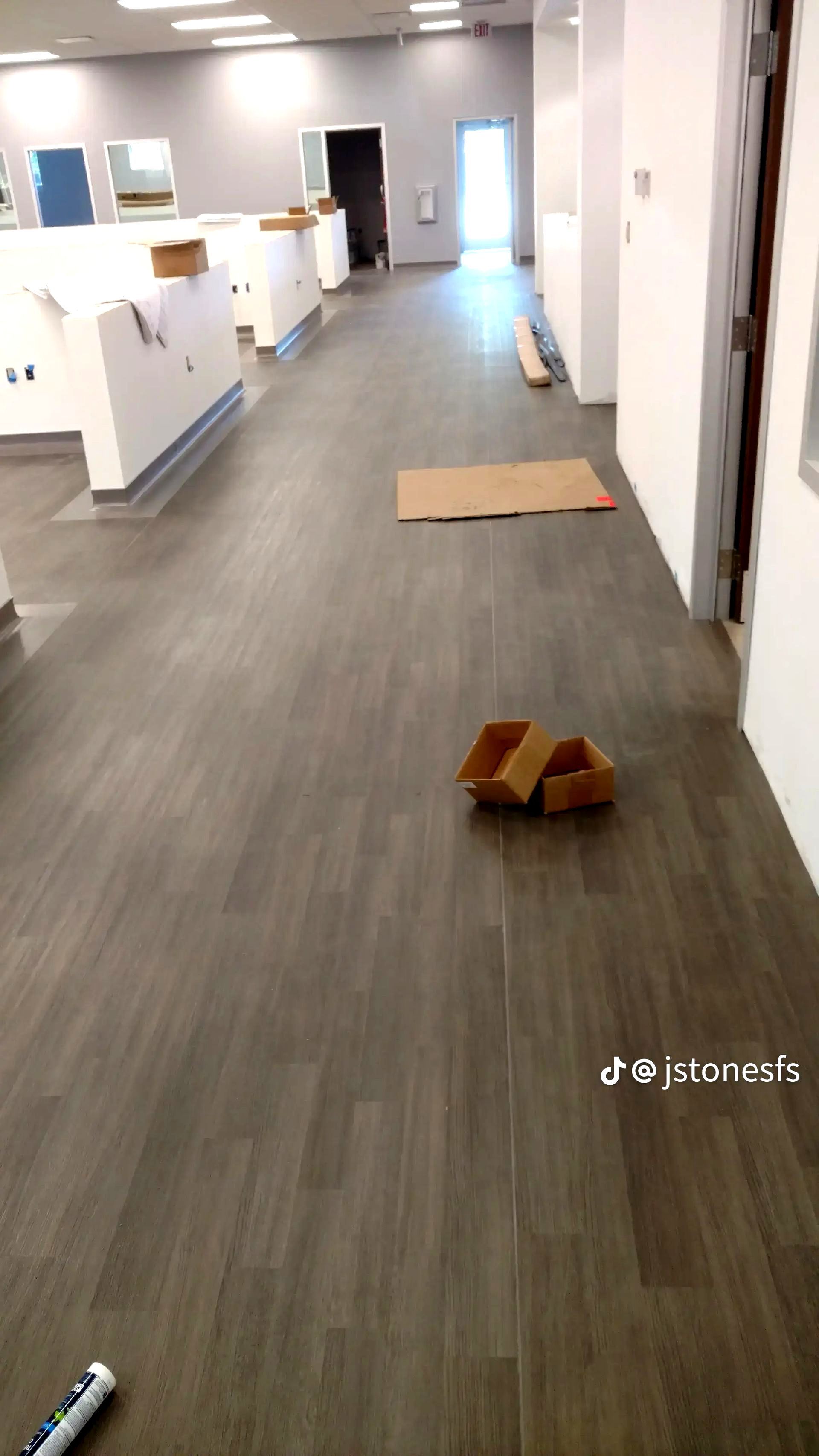 A cardboard box is laying on the floor in a hallway.