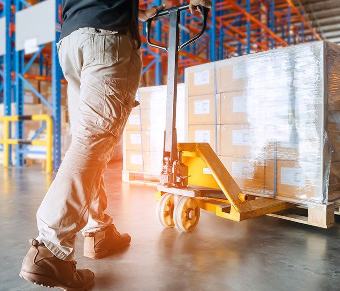 Worker Holding Pallet Truck — Piscataway, NJ — Central Forklift Inc.
