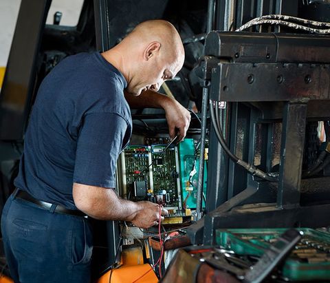 Worker Repairing Forklift — Piscataway, NJ — Central Forklift Inc.
