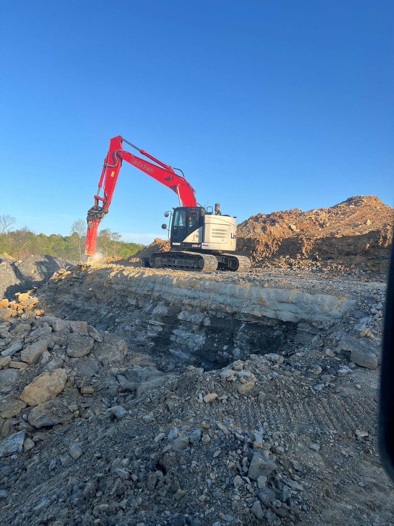 A yellow Gehl telehandler with a front fork attachment parked on a gravel surface under a cloudy sky.