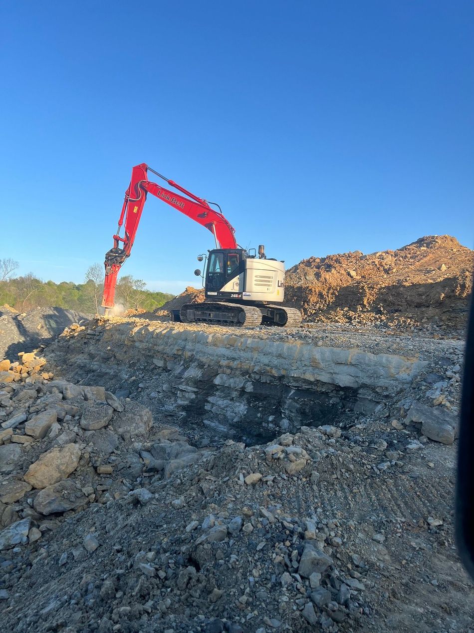 A yellow Gehl telehandler with a front fork attachment parked on a gravel surface under a cloudy sky.