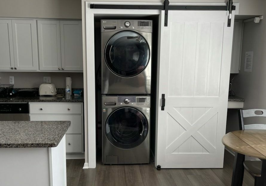 A washer and dryer are stacked on top of each other in a laundry room.