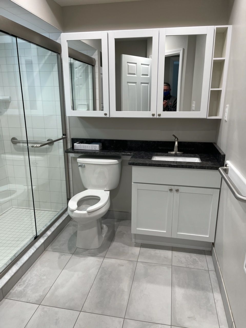 A bathroom with a toilet a sink and a shower