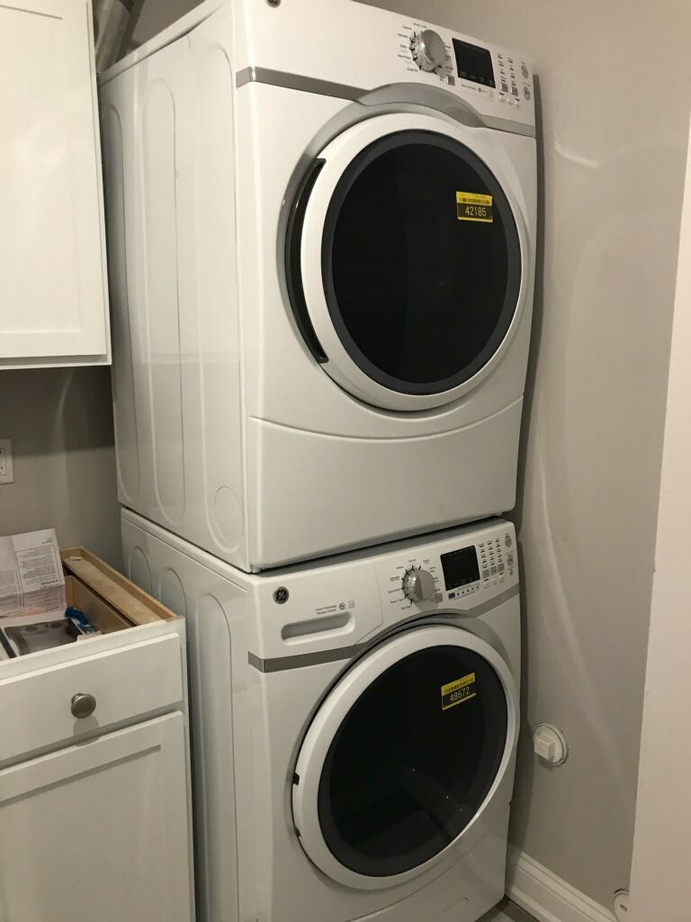 A washer and dryer are stacked on top of each other in a laundry room.