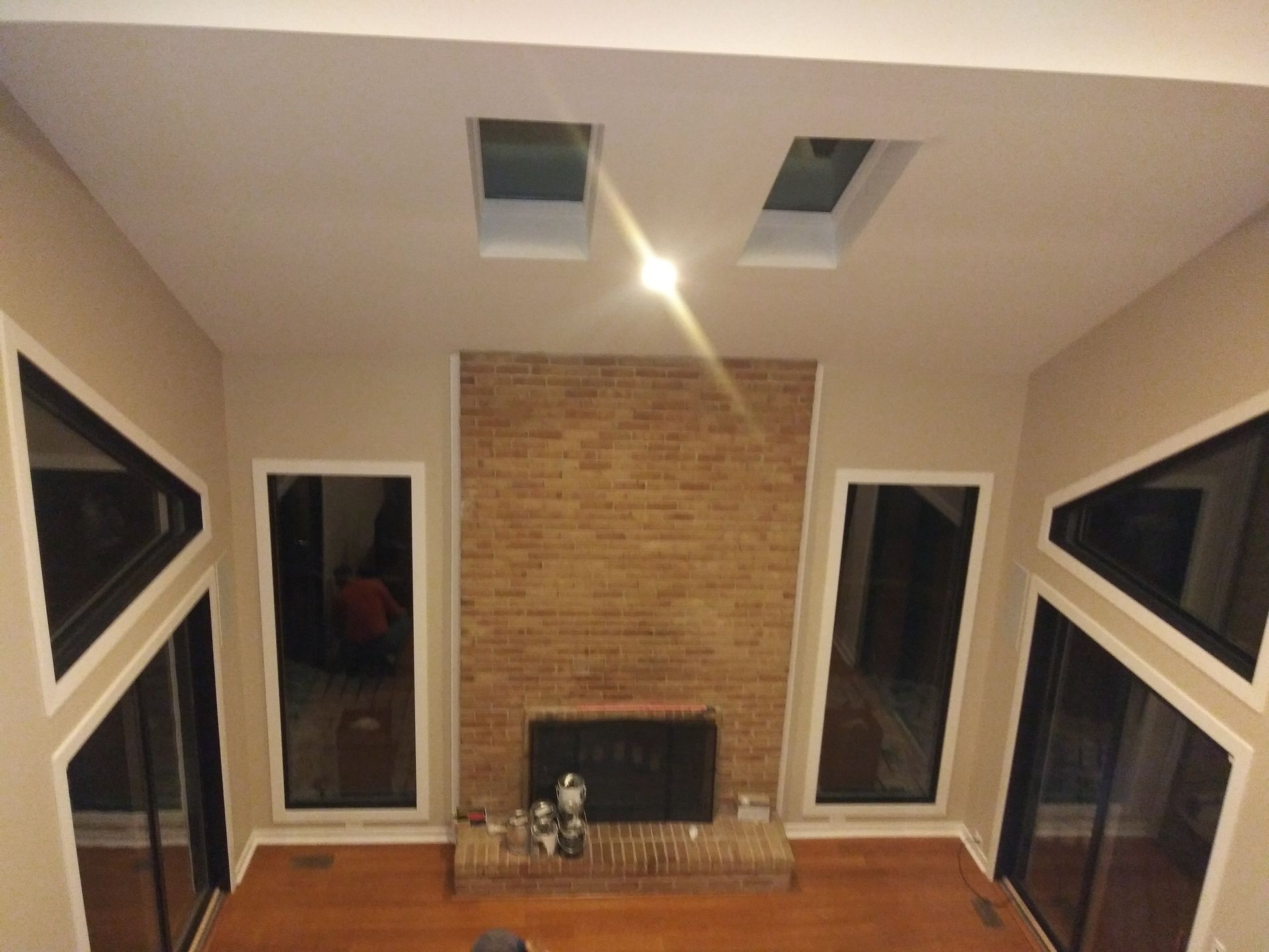 A living room with a fireplace and two skylights