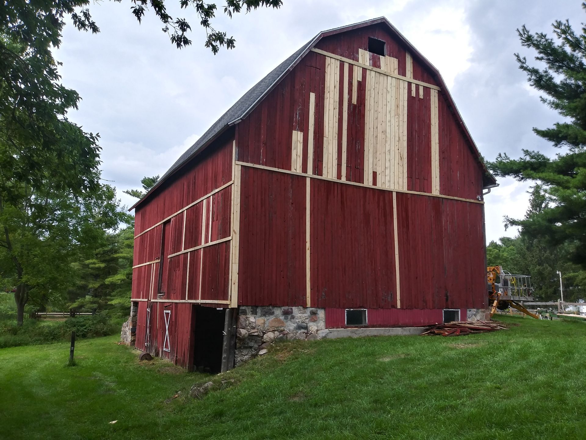 A red barn is sitting in the middle of a grassy field