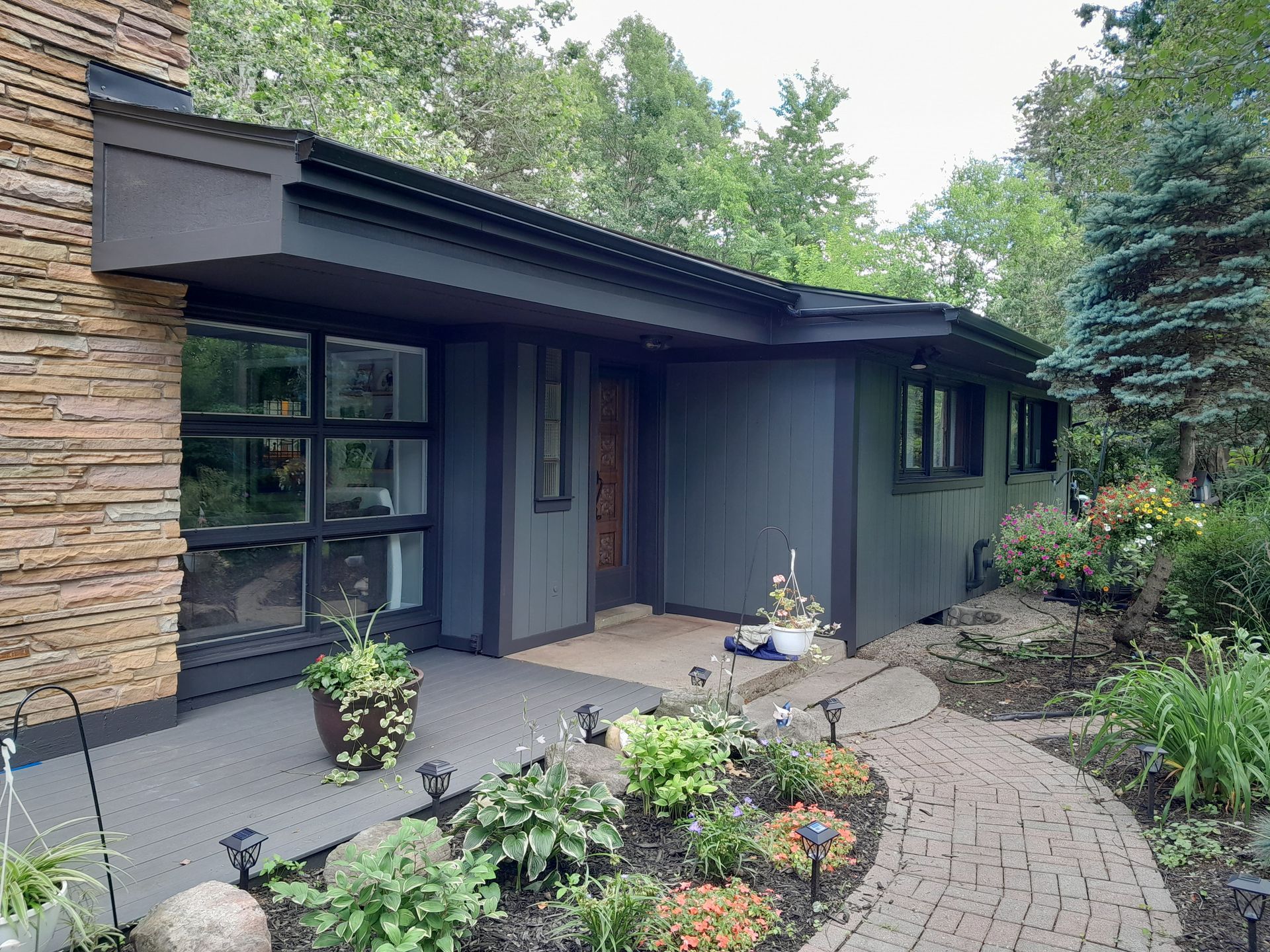 The front of a house with a brick walkway leading to it.