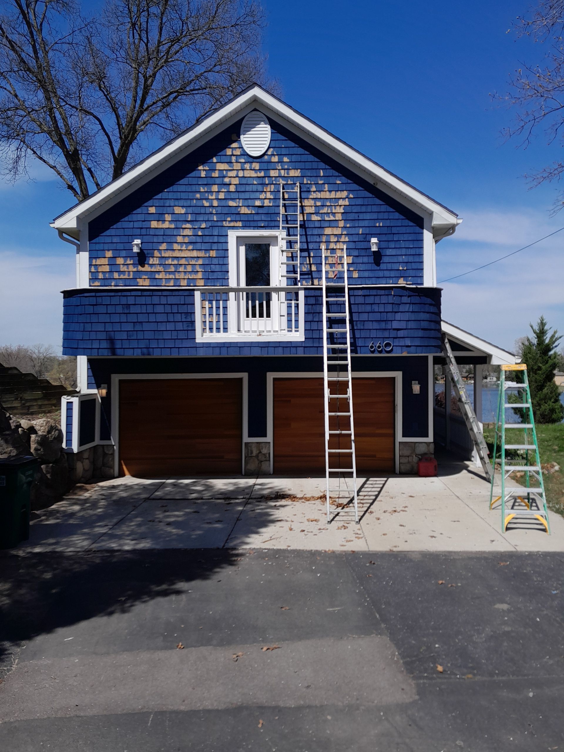 A blue house with a ladder in front of it