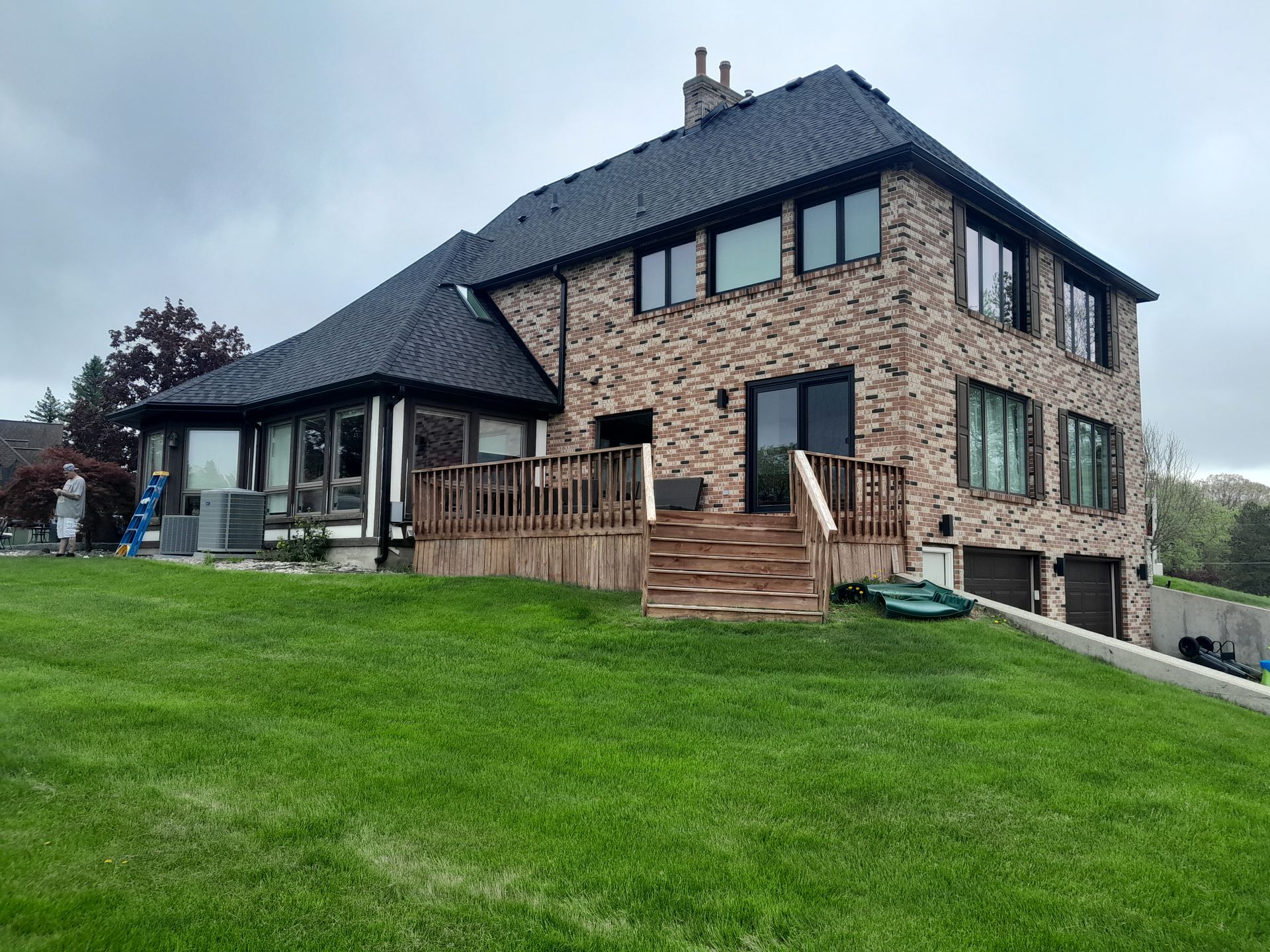 A large brick house with a large lawn in front of it.