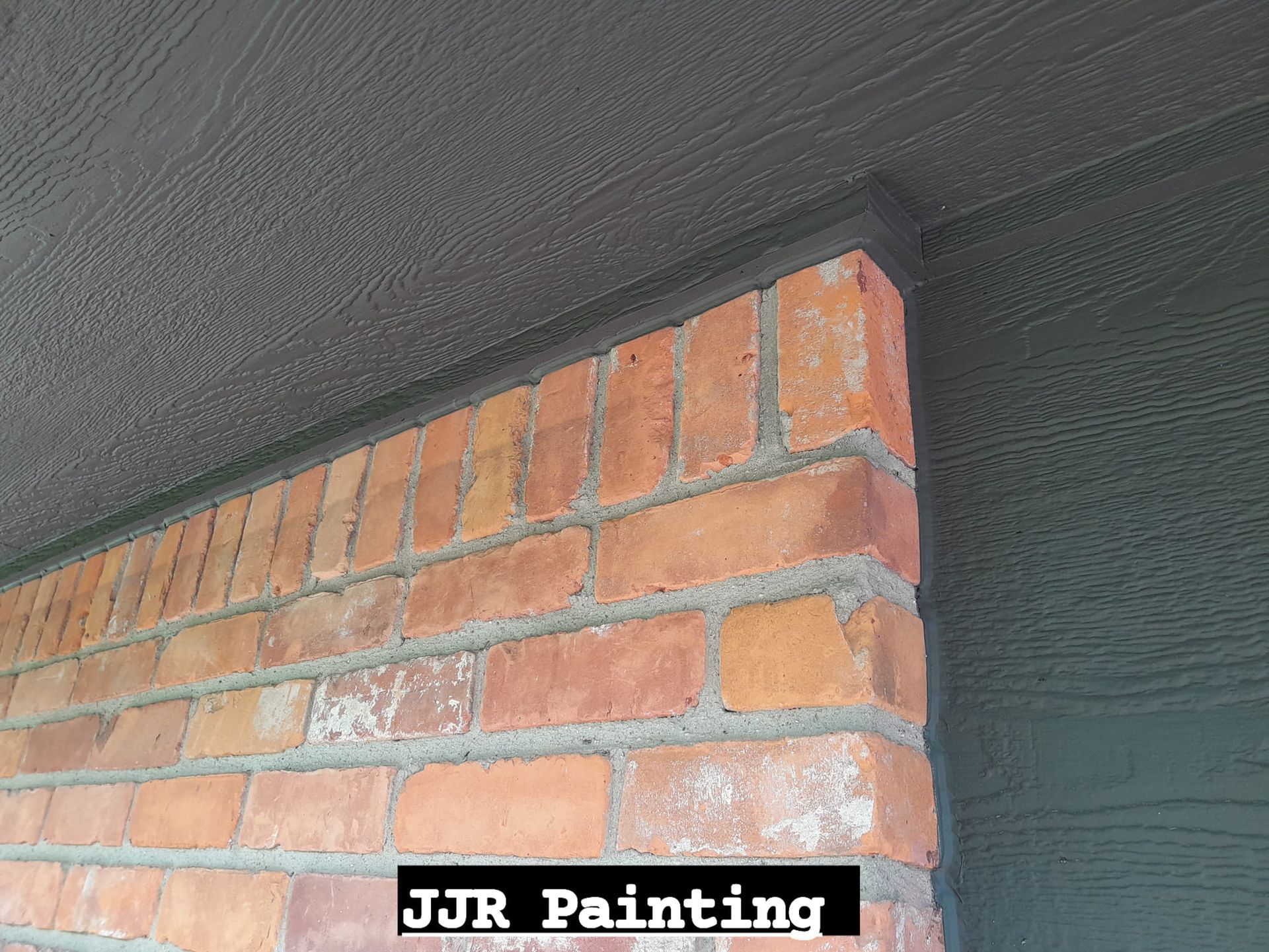 A brick wall is being painted by jjr painting