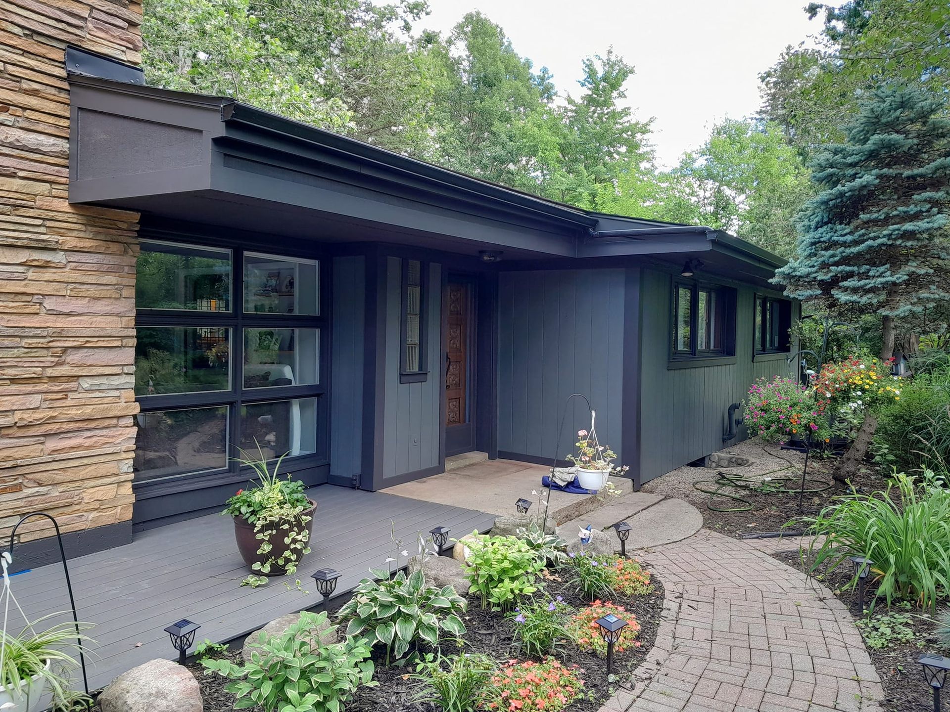 The front of a house with a brick walkway leading to it.