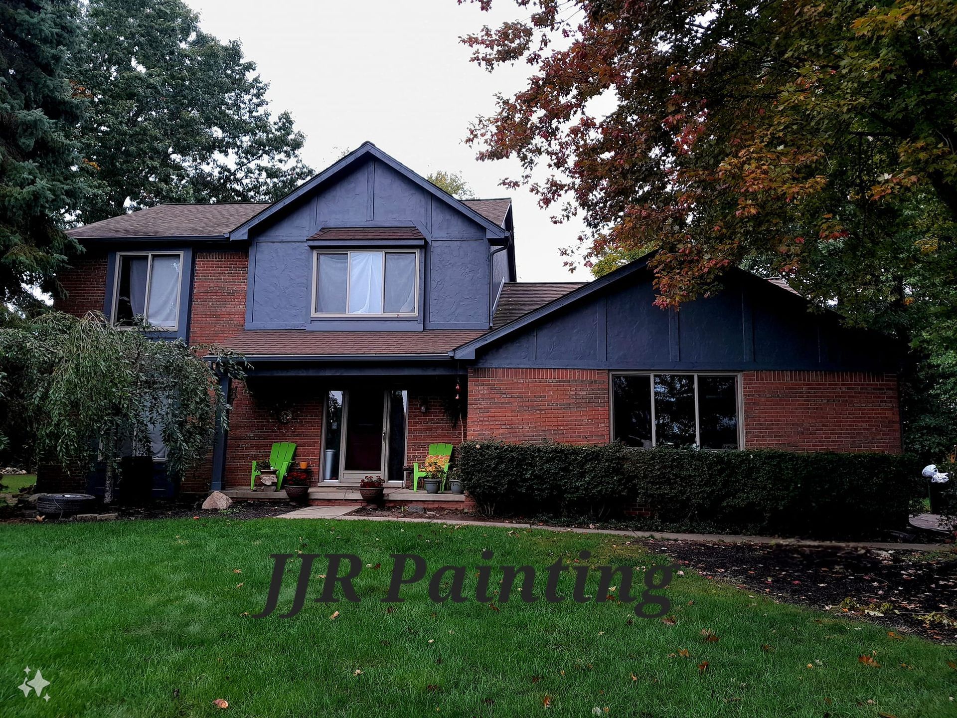 A brick house with blue siding and a jr painting logo