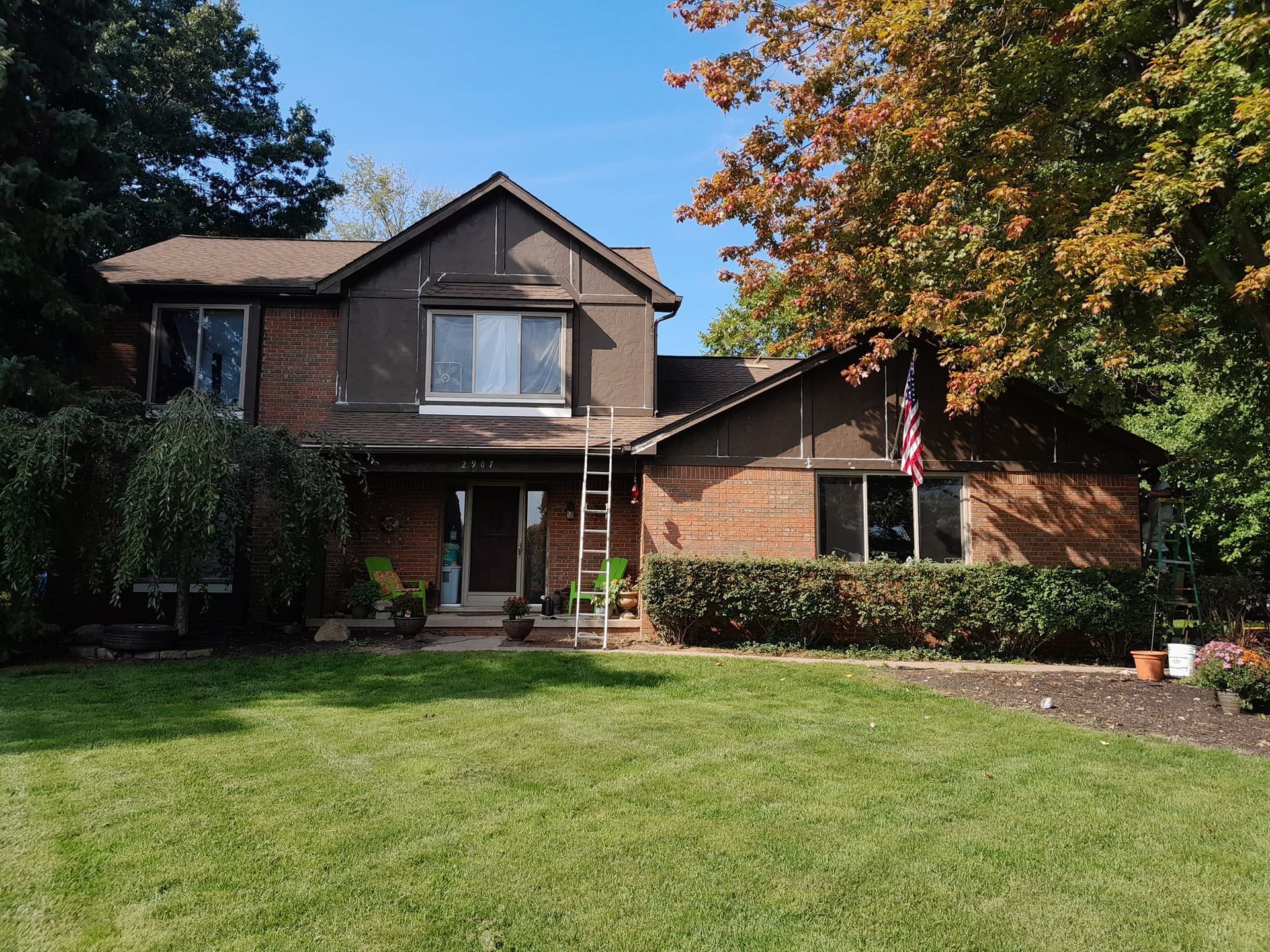 A large brick house with a large lawn in front of it