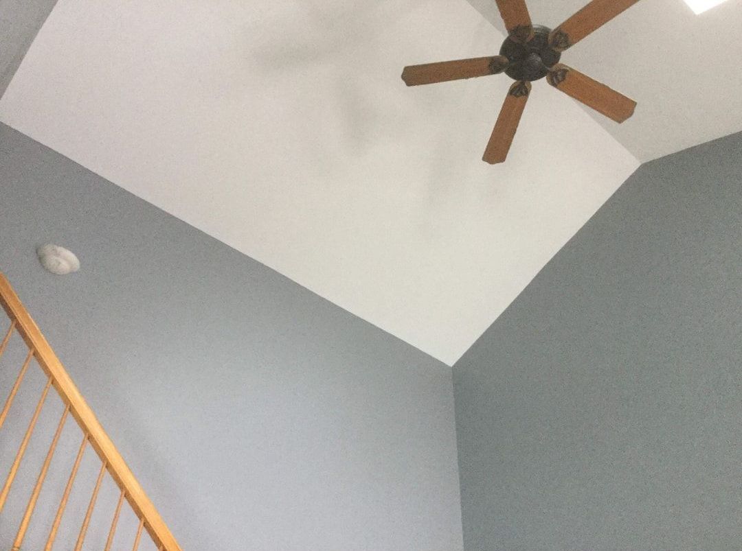 A ceiling fan is hanging from the ceiling of a room