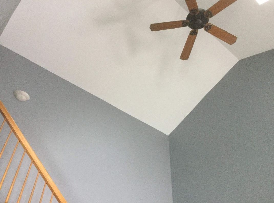 A ceiling fan is hanging from the ceiling of a room