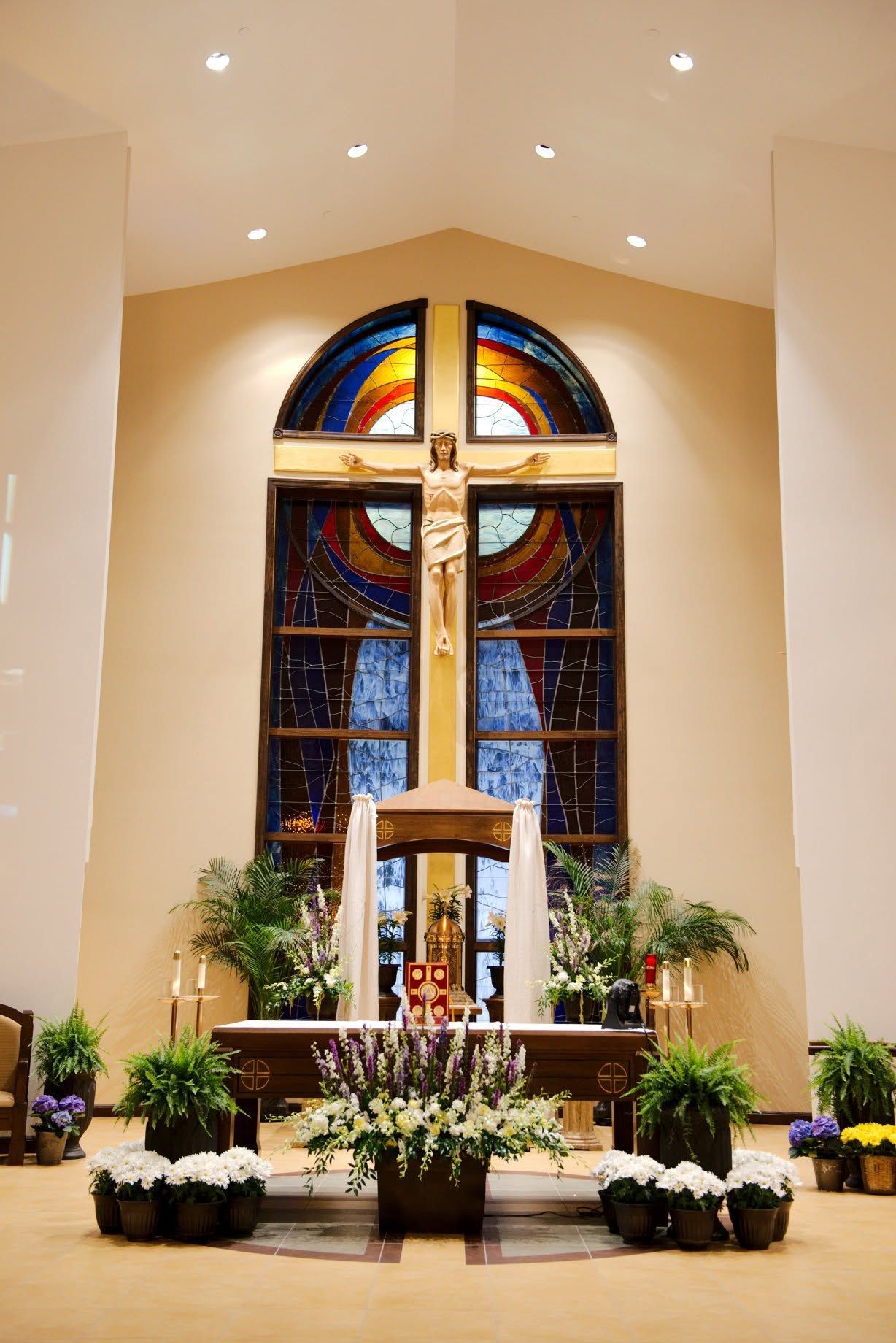 Ornate church altar with gold mosaic, striped brick arches, and candles in the sanctuary