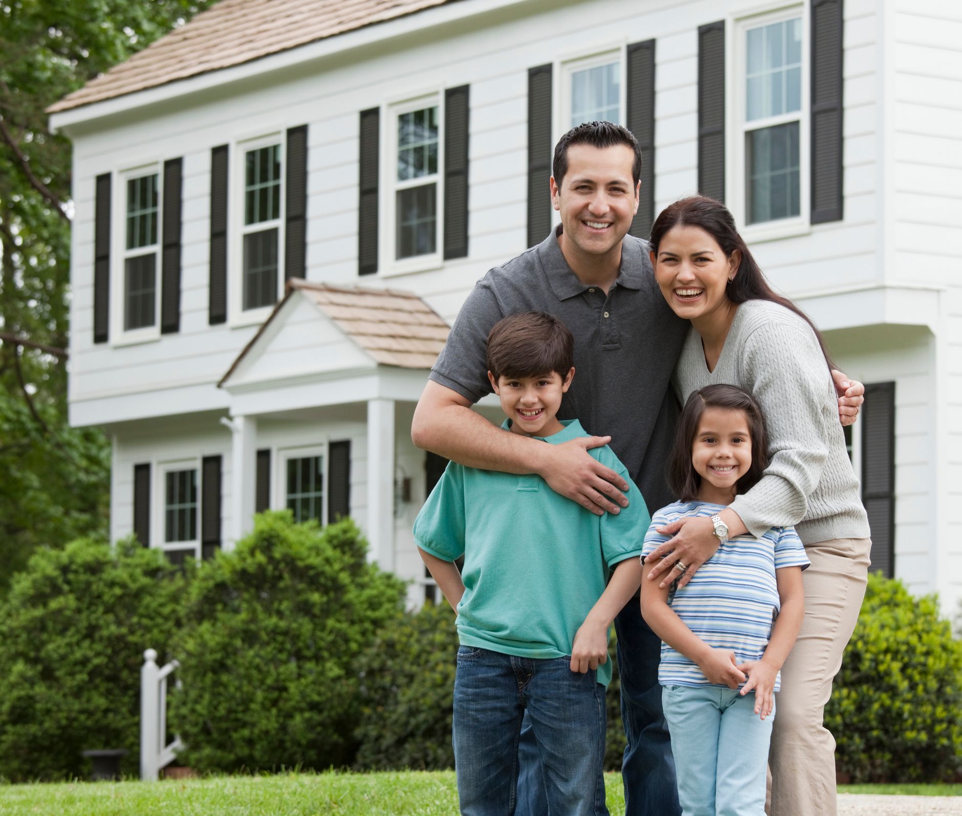 A gavel striking a wooden block next to a miniature house on a reflective surface.