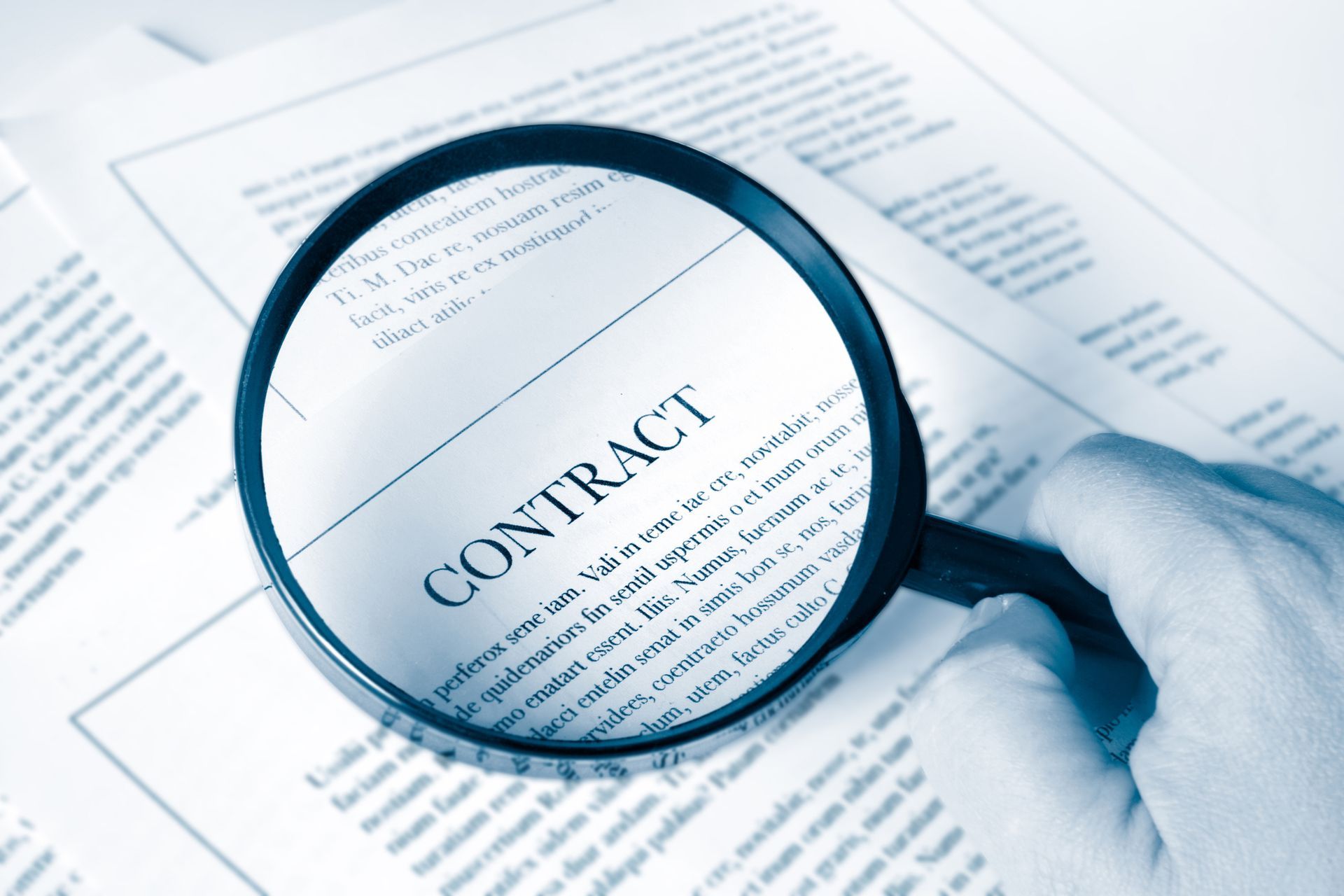 Magnifying glass over a contract document.