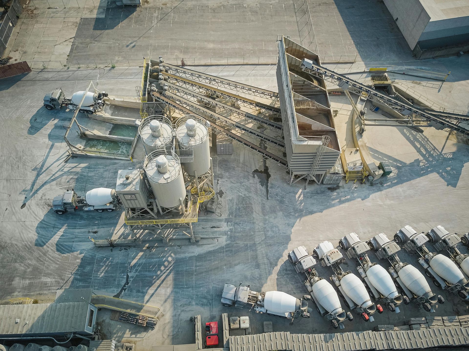 Industrial Yard with Silos, Conveyors, and Parked Concrete Mixer — Rainbow and Sons Heavy Haulage in Wells Crossing, NSW