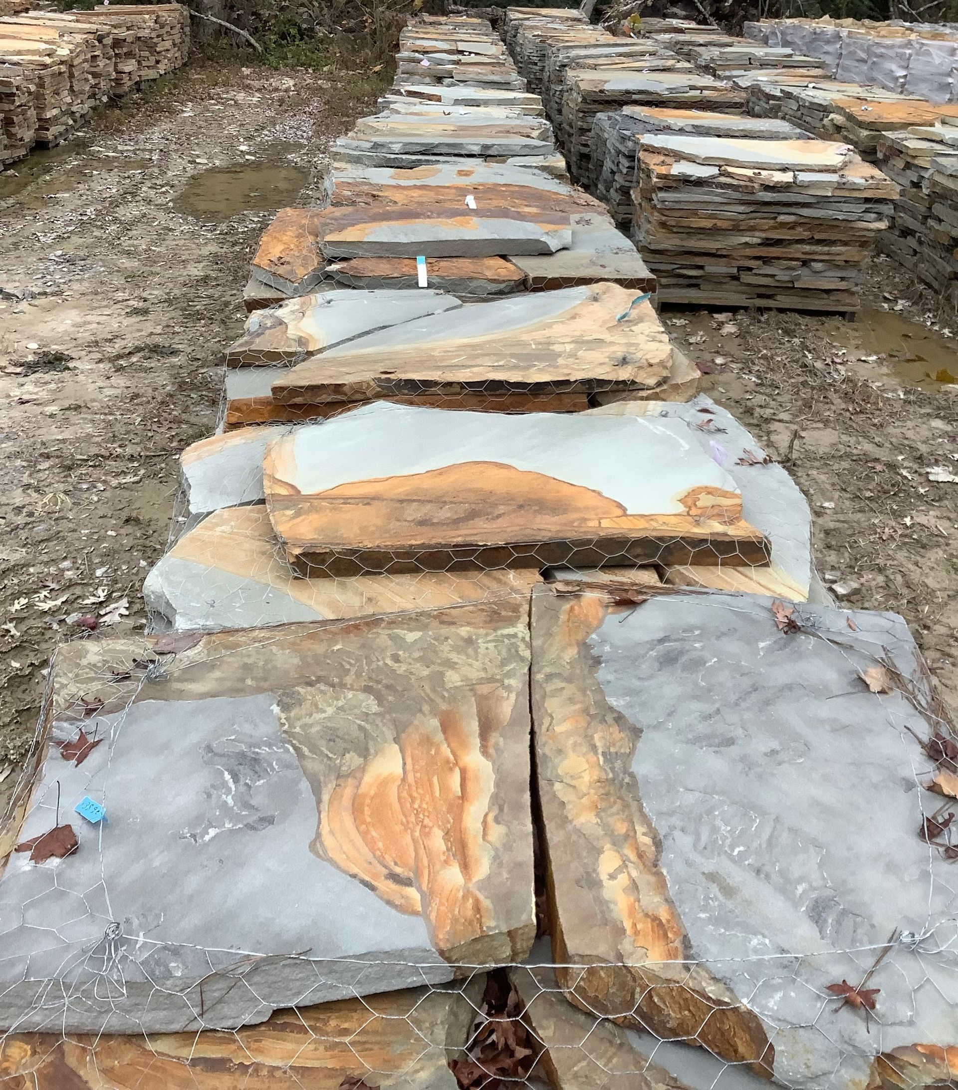 A row of rocks sitting on top of each other on a dirt road.
