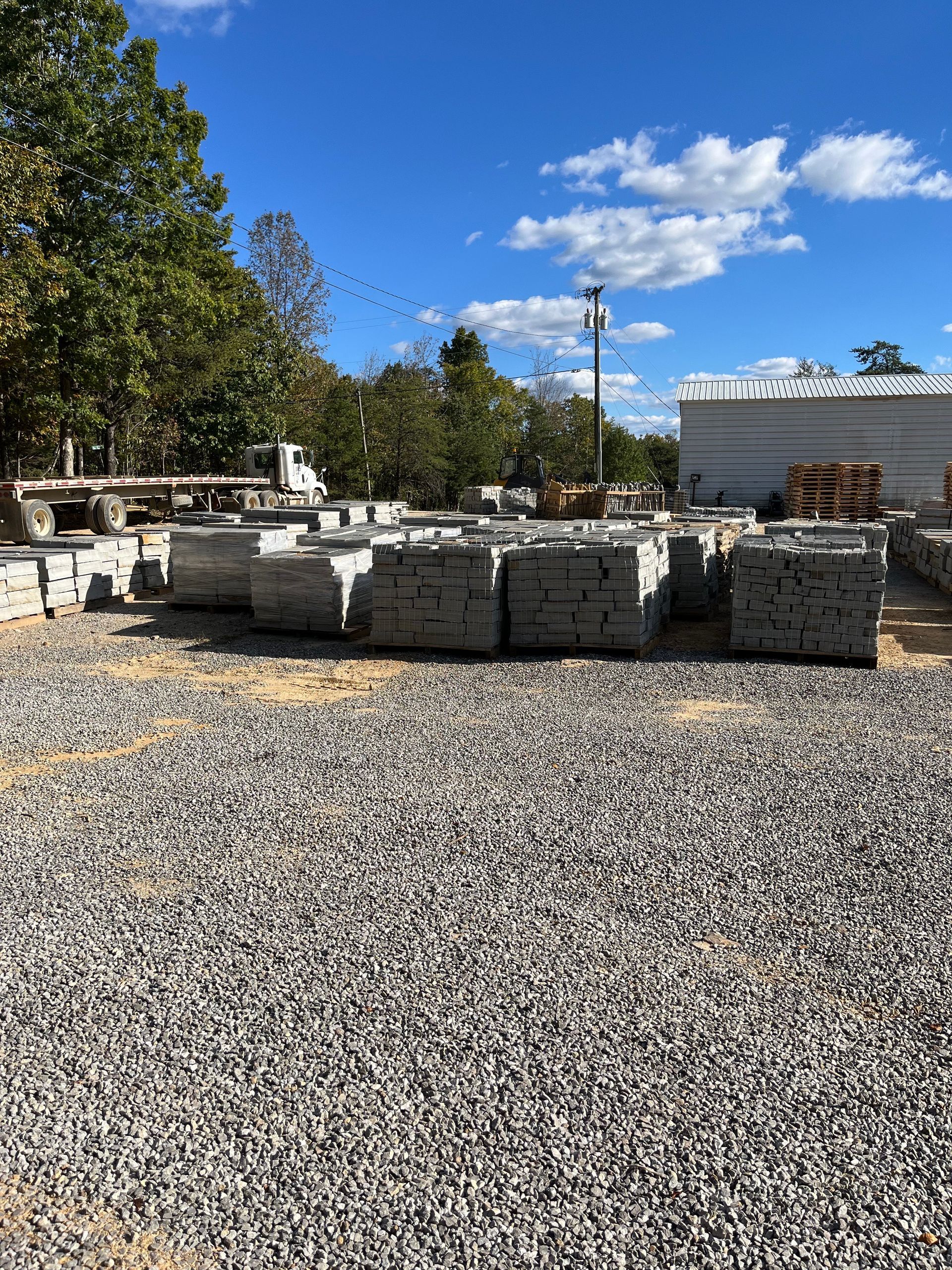 A pile of concrete blocks sitting on top of a gravel lot.