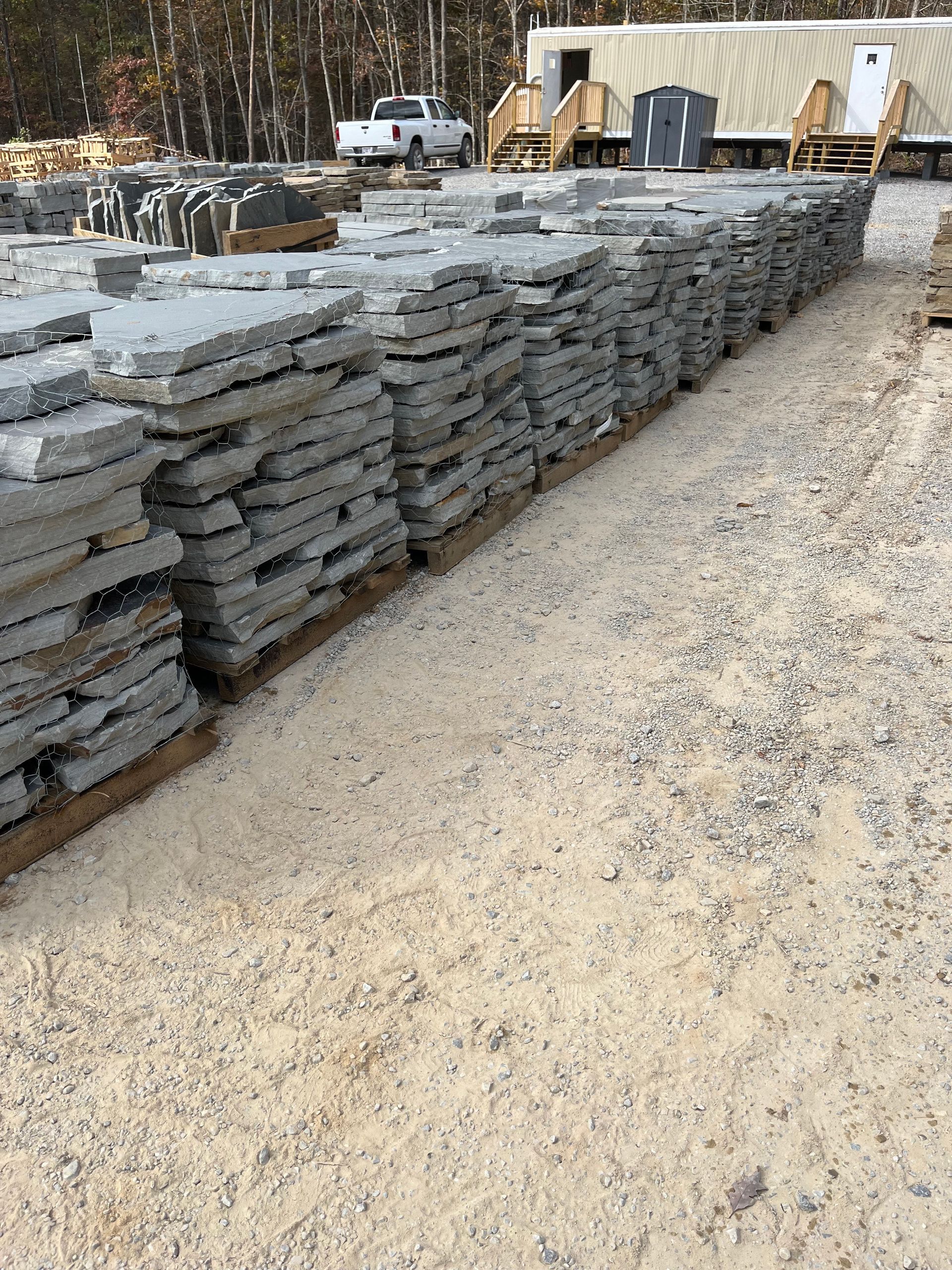 A warehouse filled with lots of pallets of rocks and gravel.
