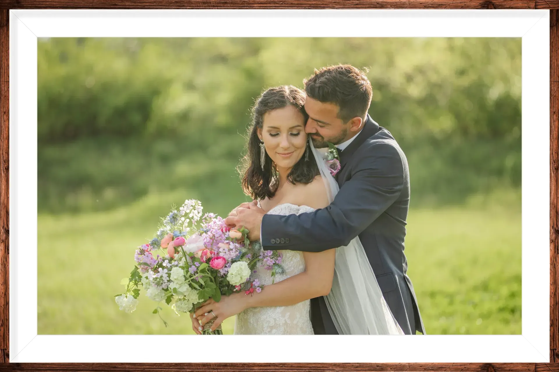 A bride and groom are posing for a picture in a field.