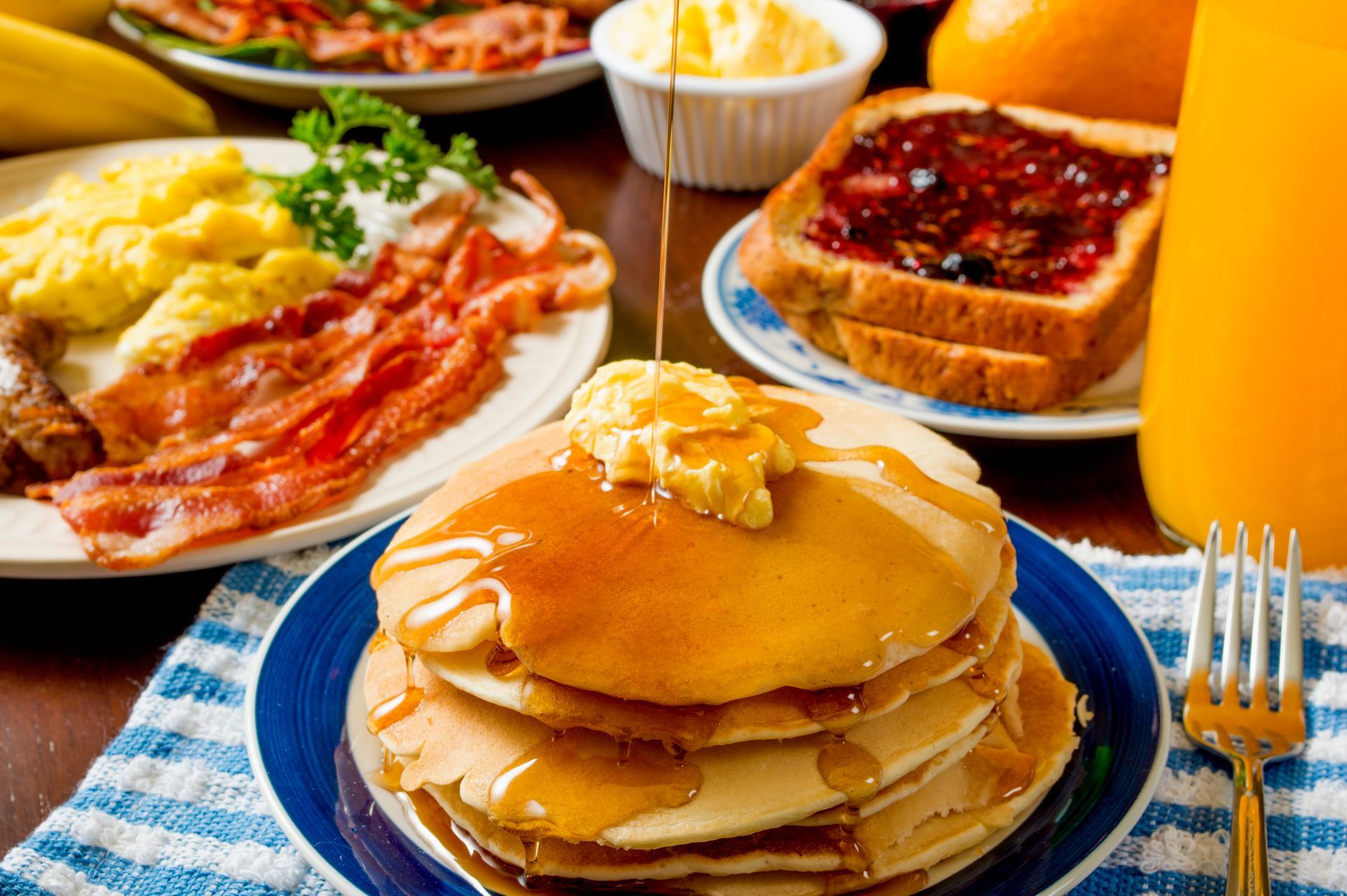 A stack of pancakes with syrup and butter on a plate.