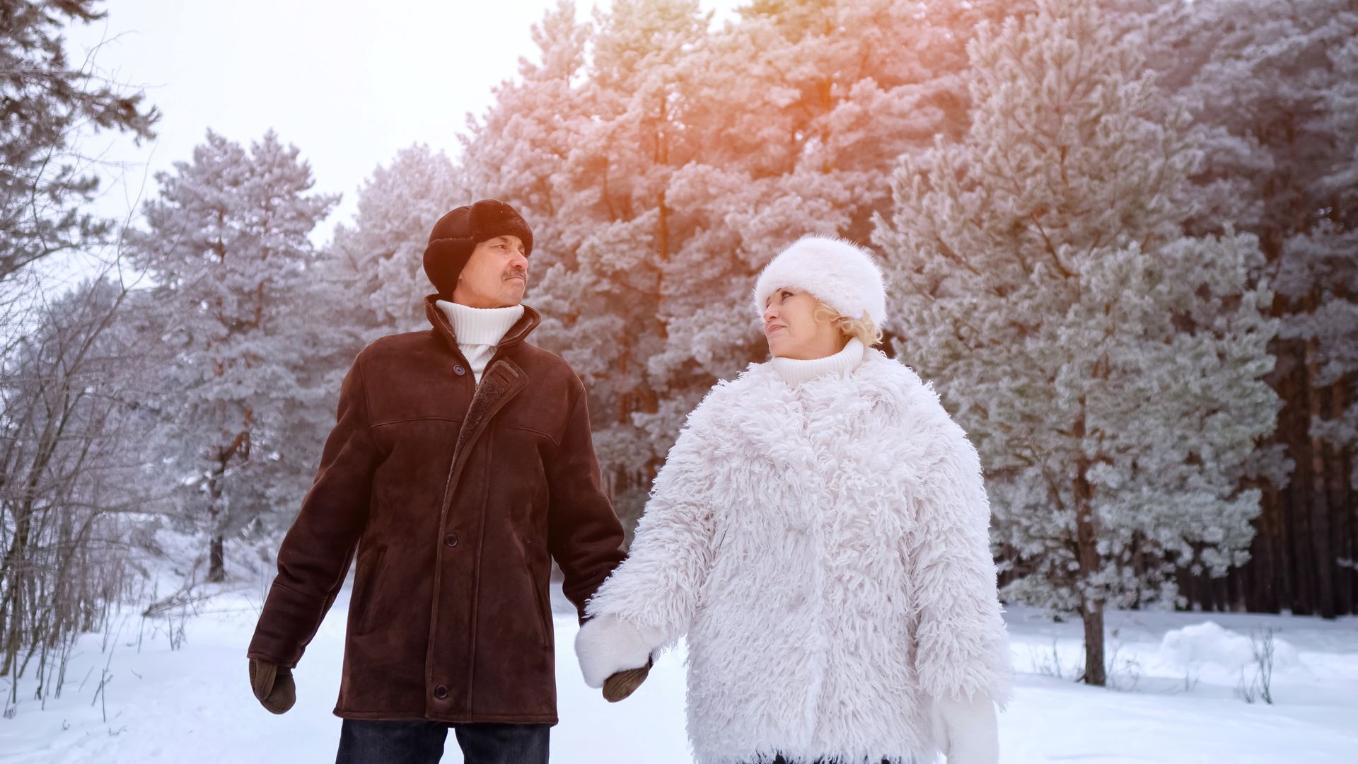 couple walking thorugh winter landscape holding hands
