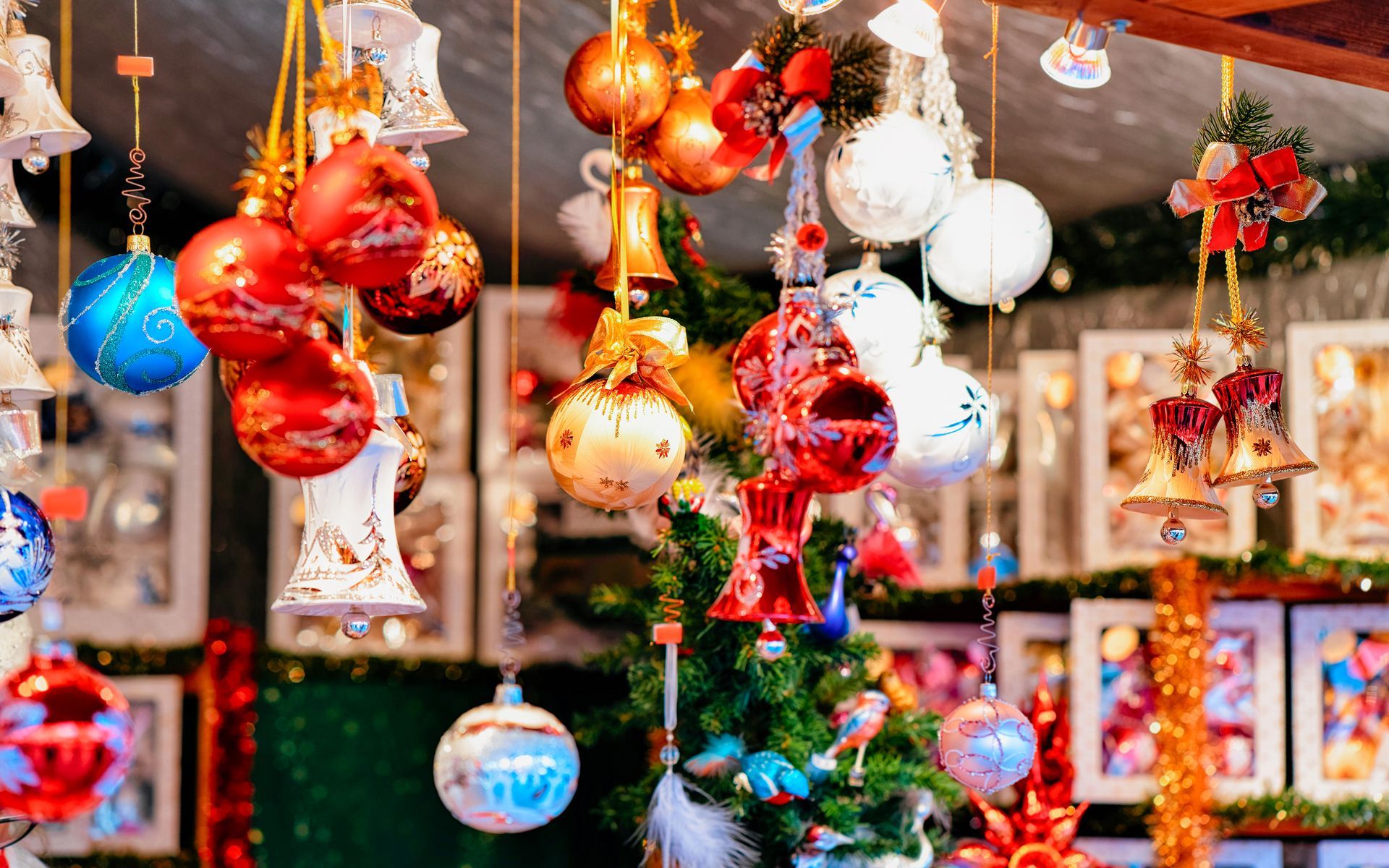 Christmas market stall with ornaments and bells hanging from the ceiling.