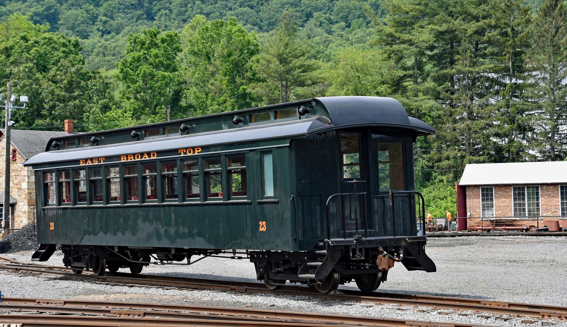 A black train car is parked on a train track.