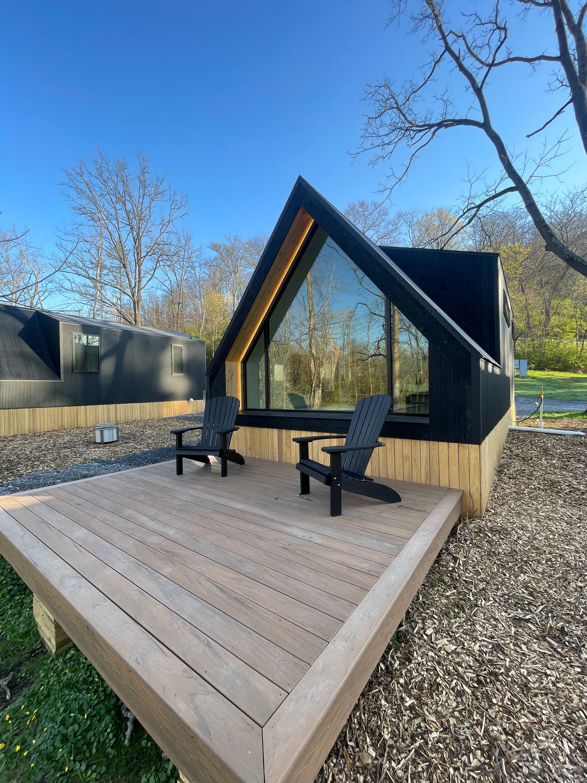 A living room with a couch , chair , and large windows.