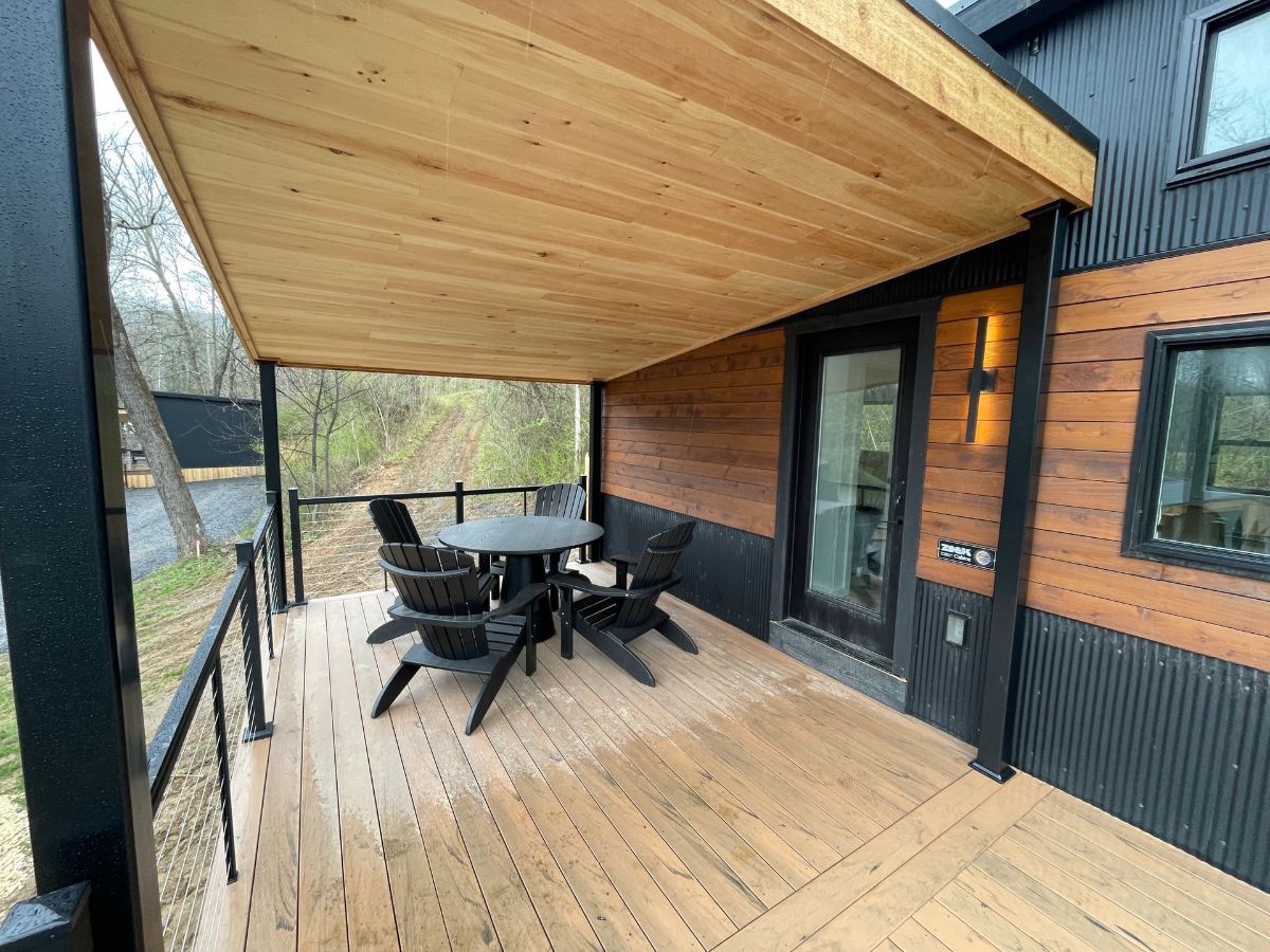A table and chairs on the deck of a cabin.