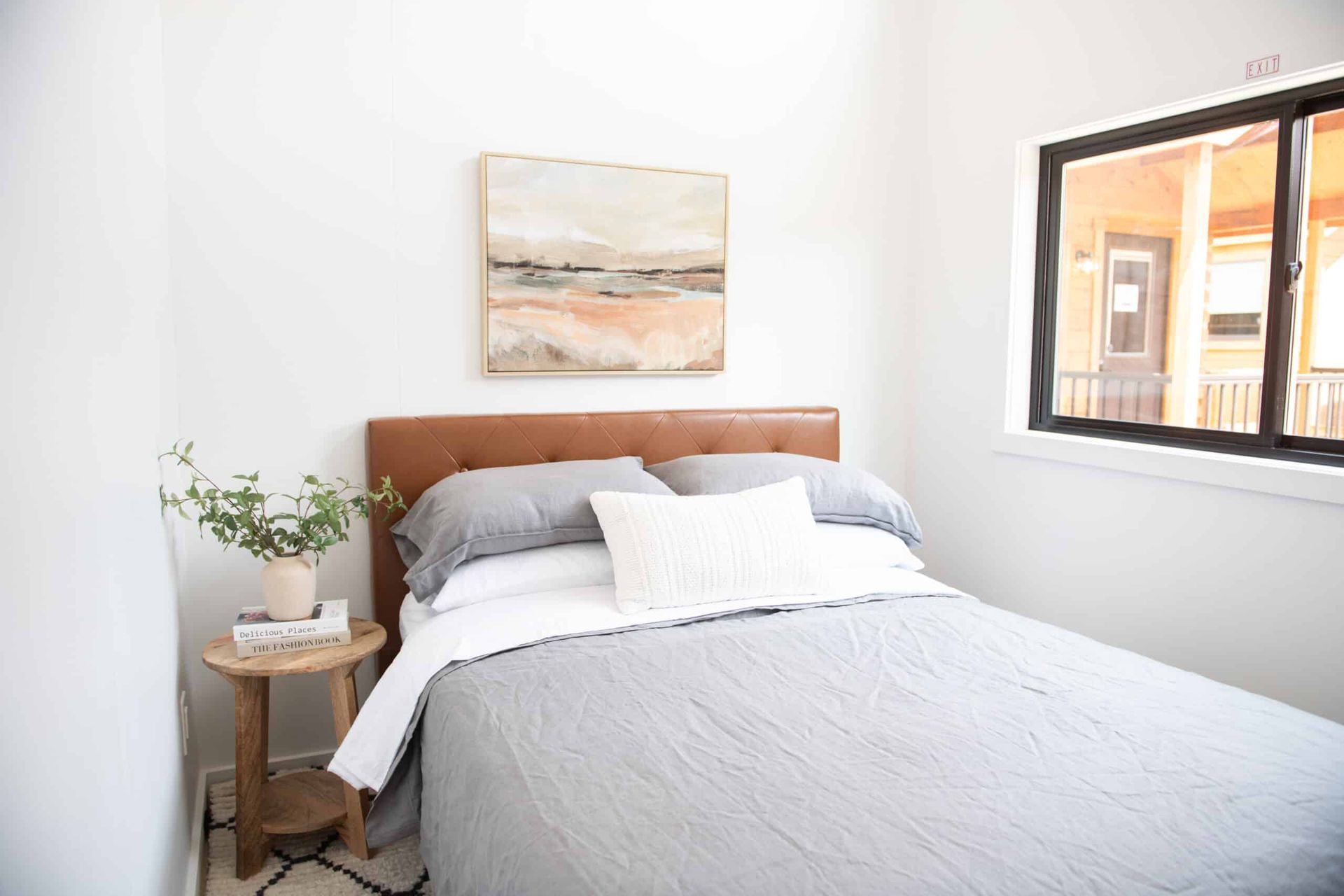 A bedroom with a bed , nightstand , and window.