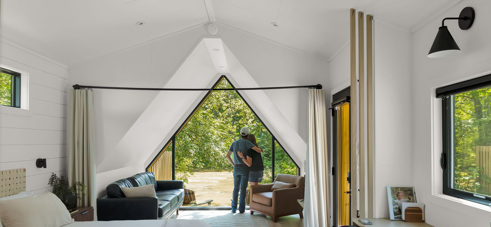 Family with a child on the father's shoulders, holding a basket of flowers, outdoors in a blooming orchard.