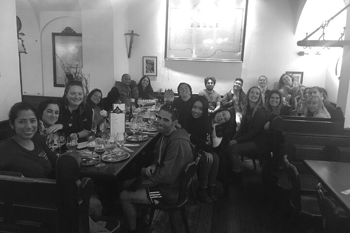A group of people are sitting at a long table in a restaurant.