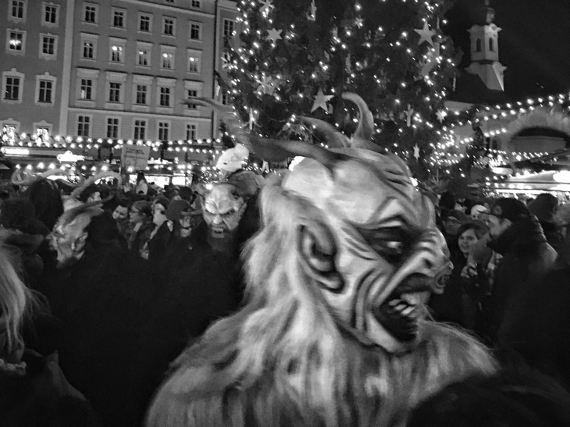 A black and white photo of a man in a devil costume