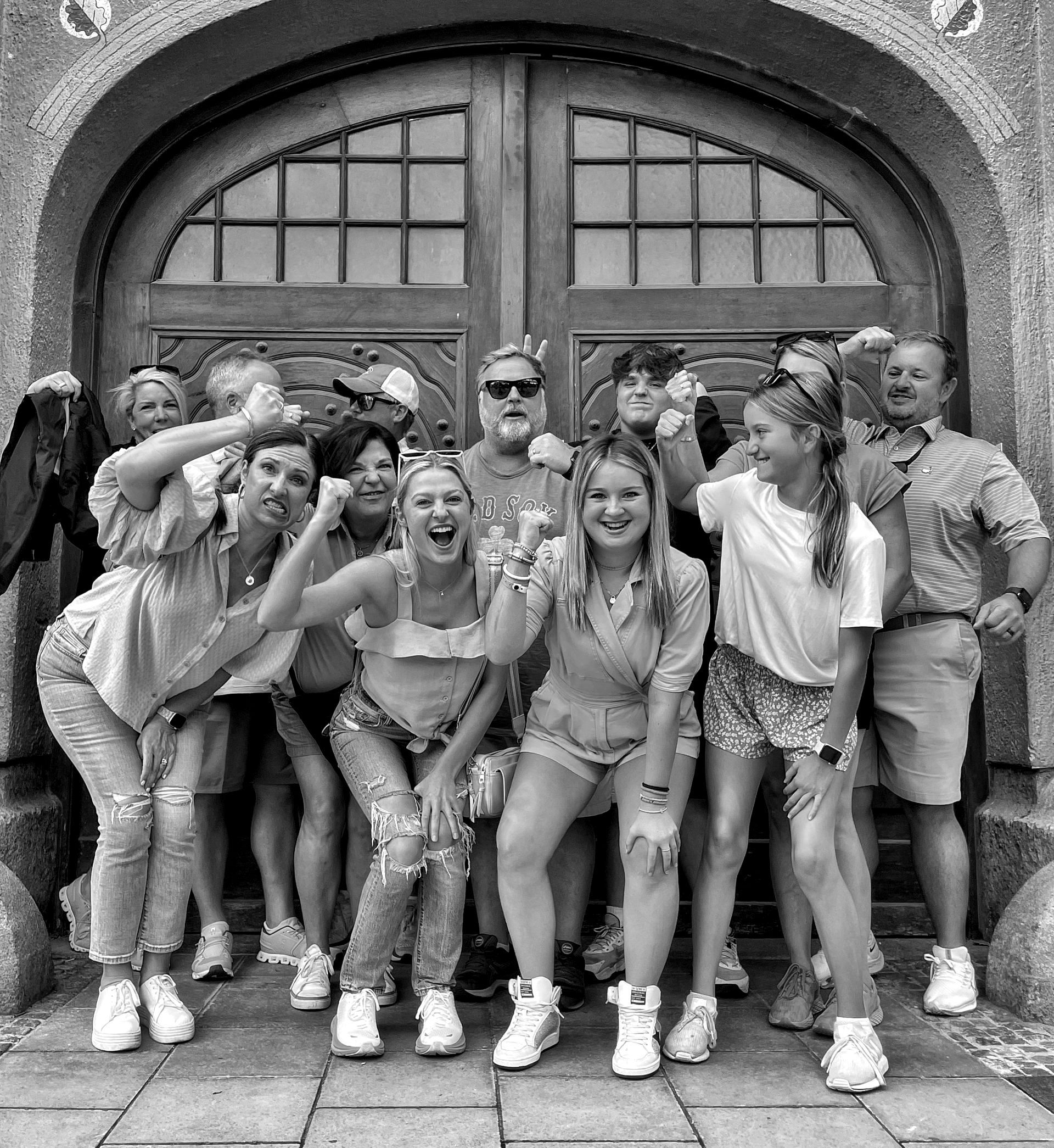 A group of people are posing for a picture in front of a building.