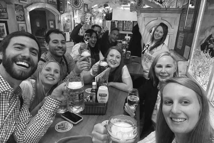 A group of people are sitting at a table drinking beer.