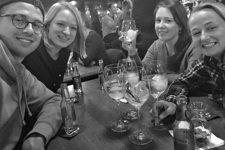 A group of people are sitting at a table holding wine glasses.