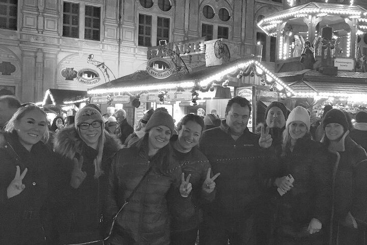 A group of people are posing for a picture at a christmas market.