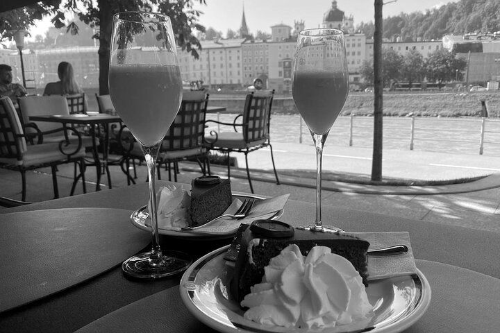 A black and white photo of two glasses of wine and a plate of food