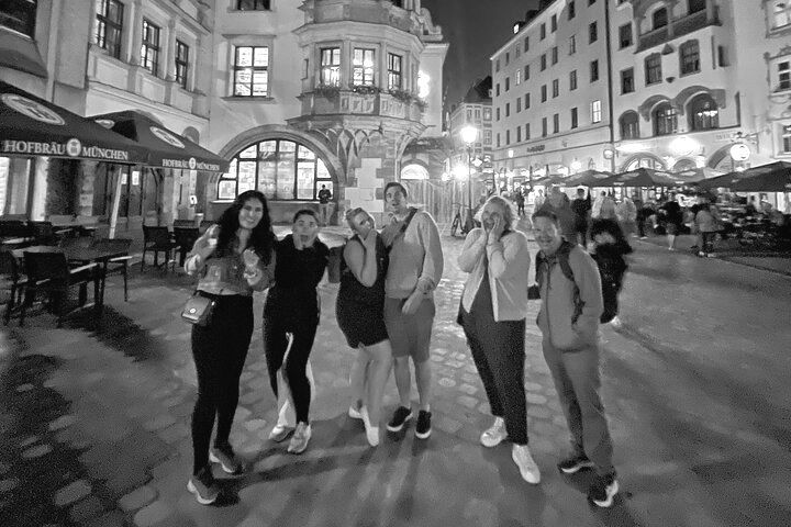 A group of people are posing for a picture in front of a building.
