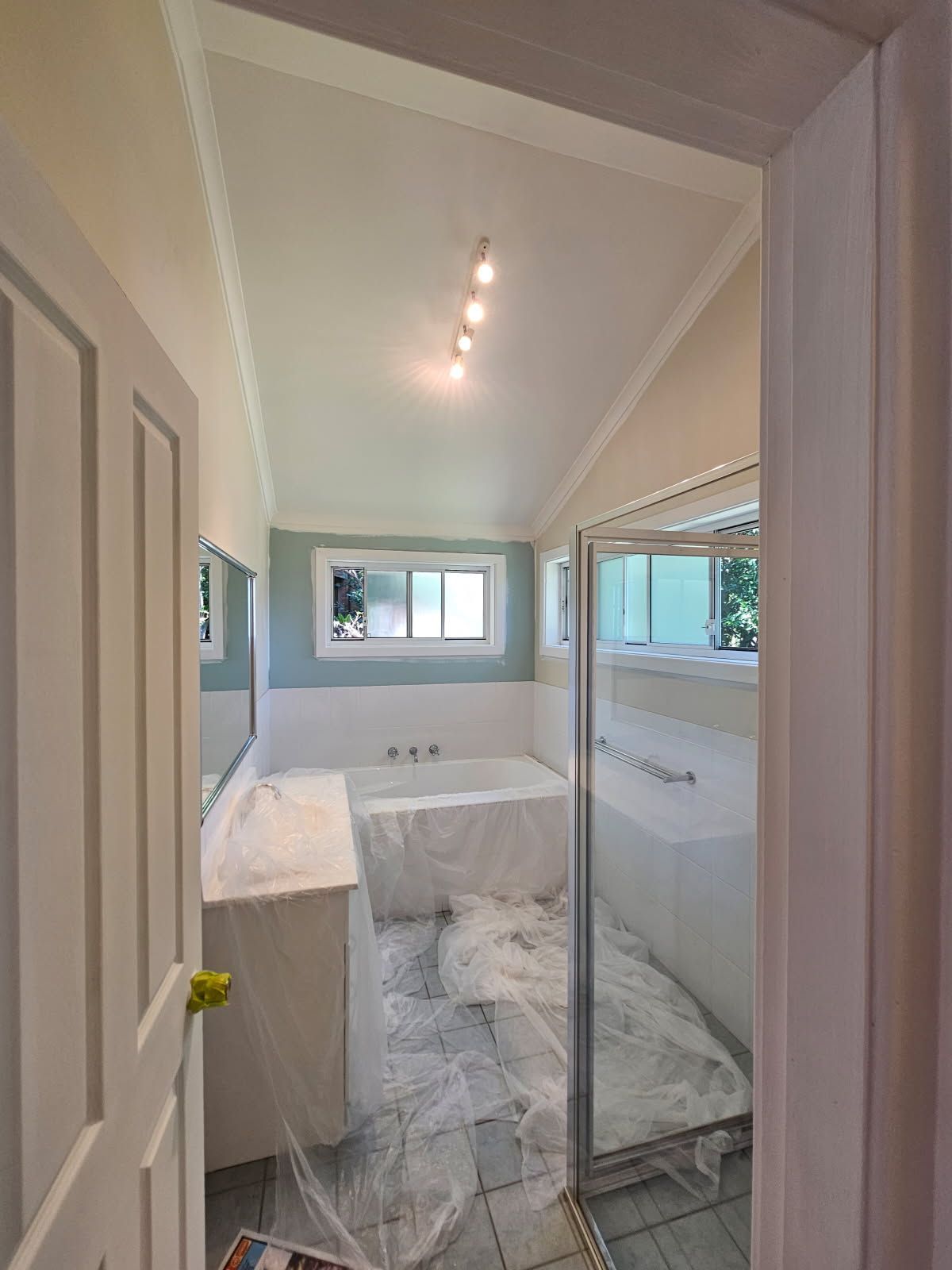 A bathroom with a tub , sink , mirror and shower.