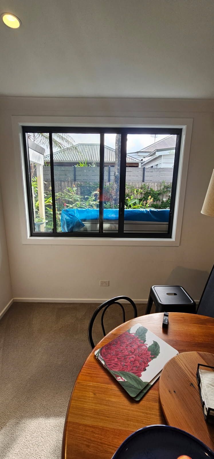 A dining room with a table and chairs and a large window.