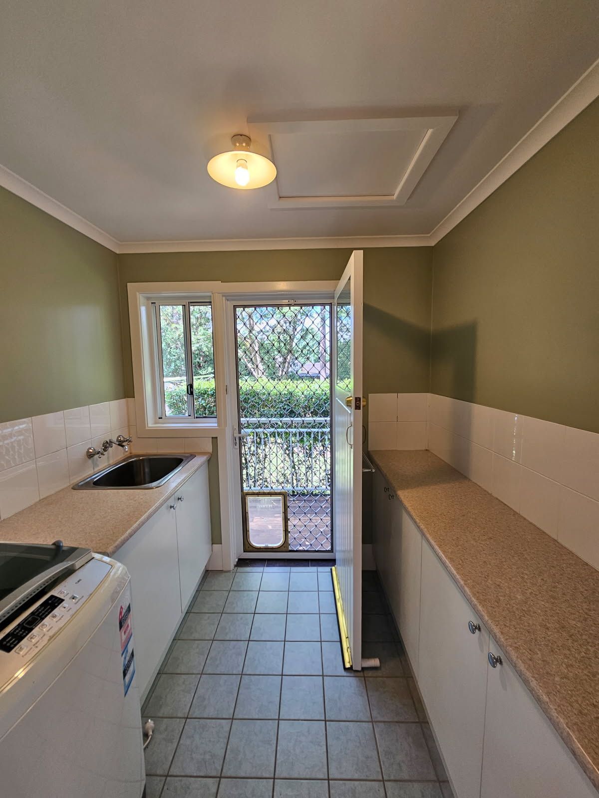 A kitchen with a washing machine and a sink