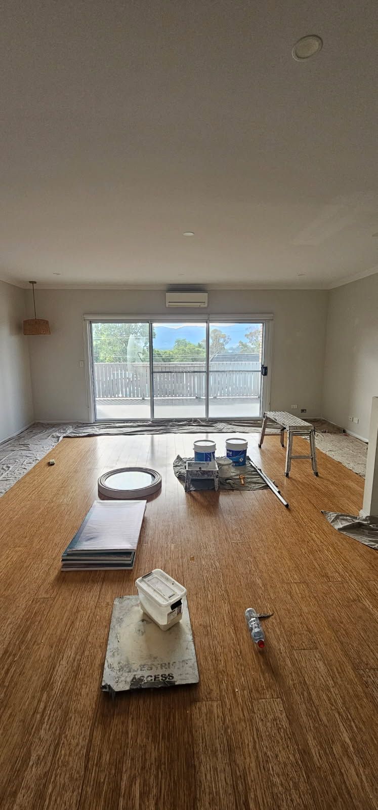 A living room with a wooden floor and a large window.