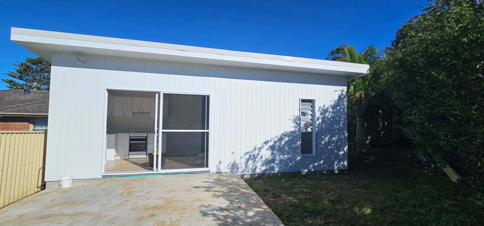 A small white house with a driveway leading to it